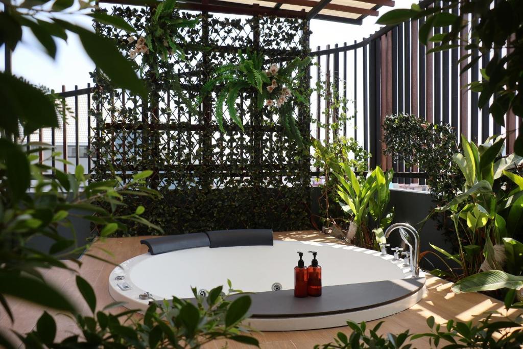 A round outdoor hot tub tucked into a leafy planted terrace.