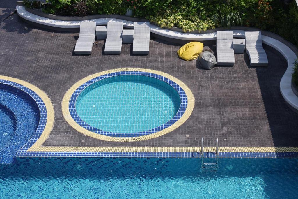 A tiled outdoor pool with a smaller circular section and surrounding loungers.