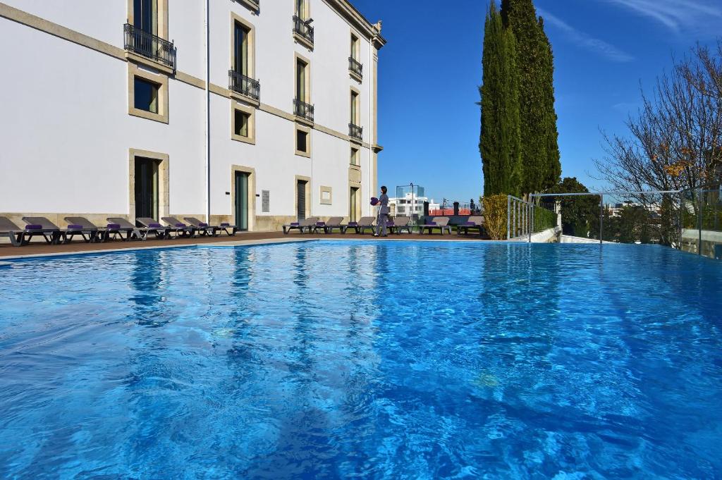une grande piscine en face d'un bâtiment dans l'établissement Pousada De Viseu, à Viseu