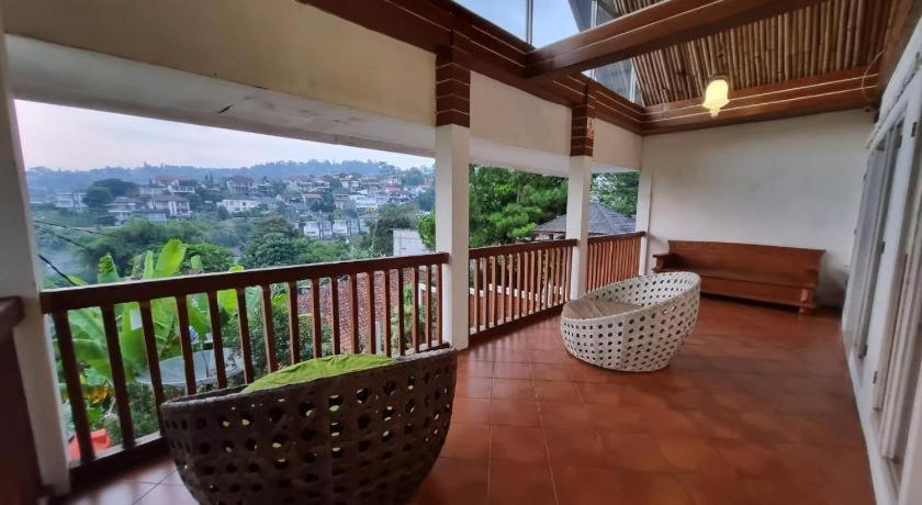 a balcony with chairs and a view of a city at Ncie property in Cangkuang