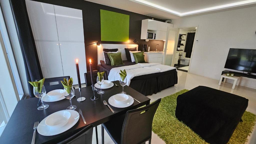 a bedroom with a bed and a table with plates on it at Eco-friendly stay with hot tub & panorama view in Oulu