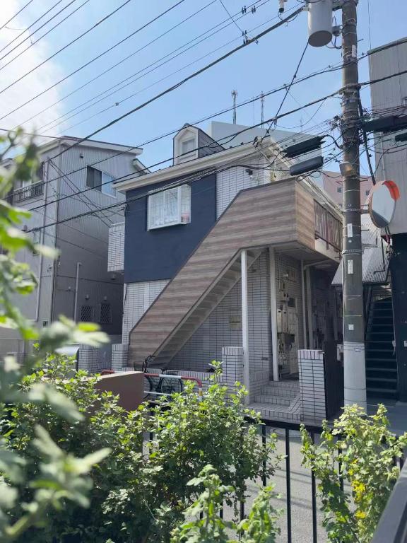 ein blau-weißes Haus mit Veranda in der Unterkunft D Regalo in Ichikawa