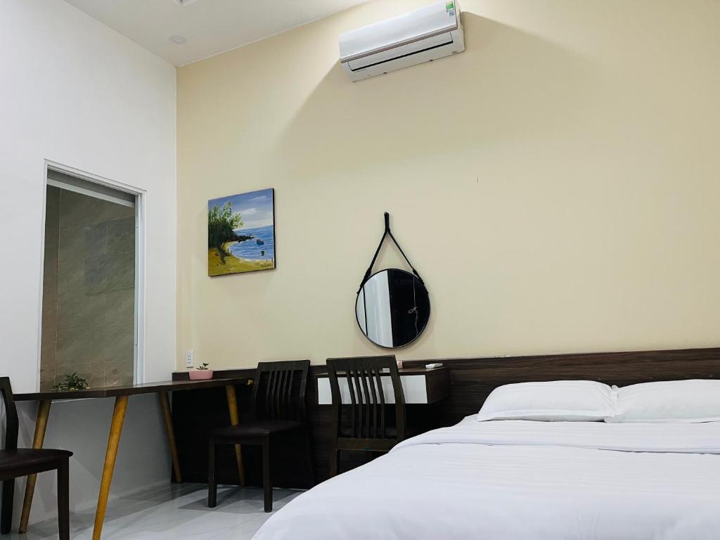 a bedroom with a bed and a mirror and chairs at AHK Homestay 1 in Phu Quoc