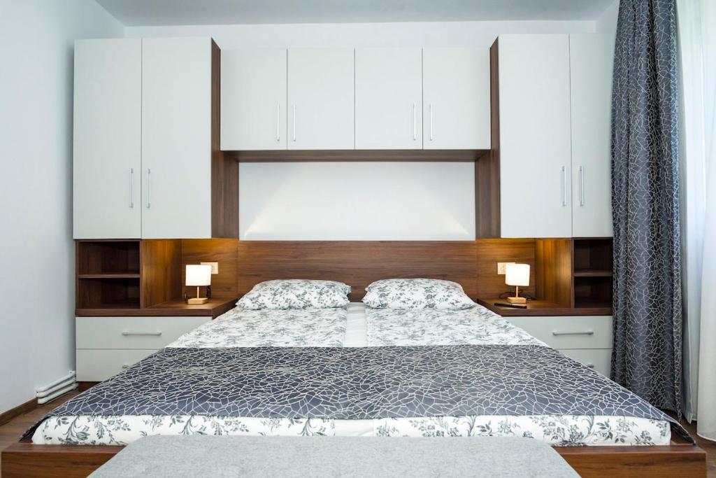 1 dormitorio con 1 cama grande y armarios blancos en Apartment in Odorheiu Secuiesc, en Văleni