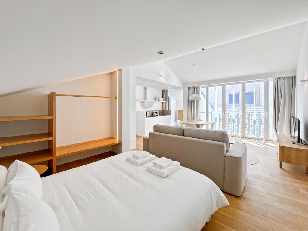 ein weißes Schlafzimmer mit einem Bett und einer Couch in der Unterkunft housingcoruña RUA DO ANXO in A Coruña