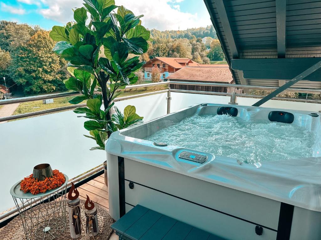 a hot tub on a balcony with a tree at Bachgeflüster-Suite in Bad Koetzting