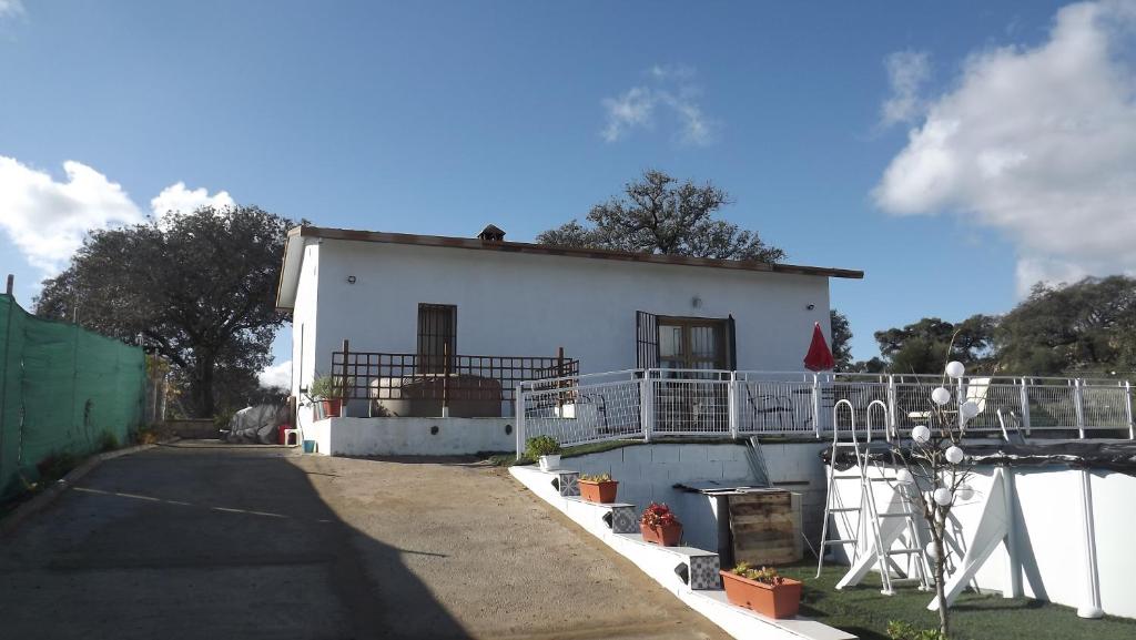 a white house with a fence around it at Villa Saudade, casa entre encinas in El Castillo de las Guardas