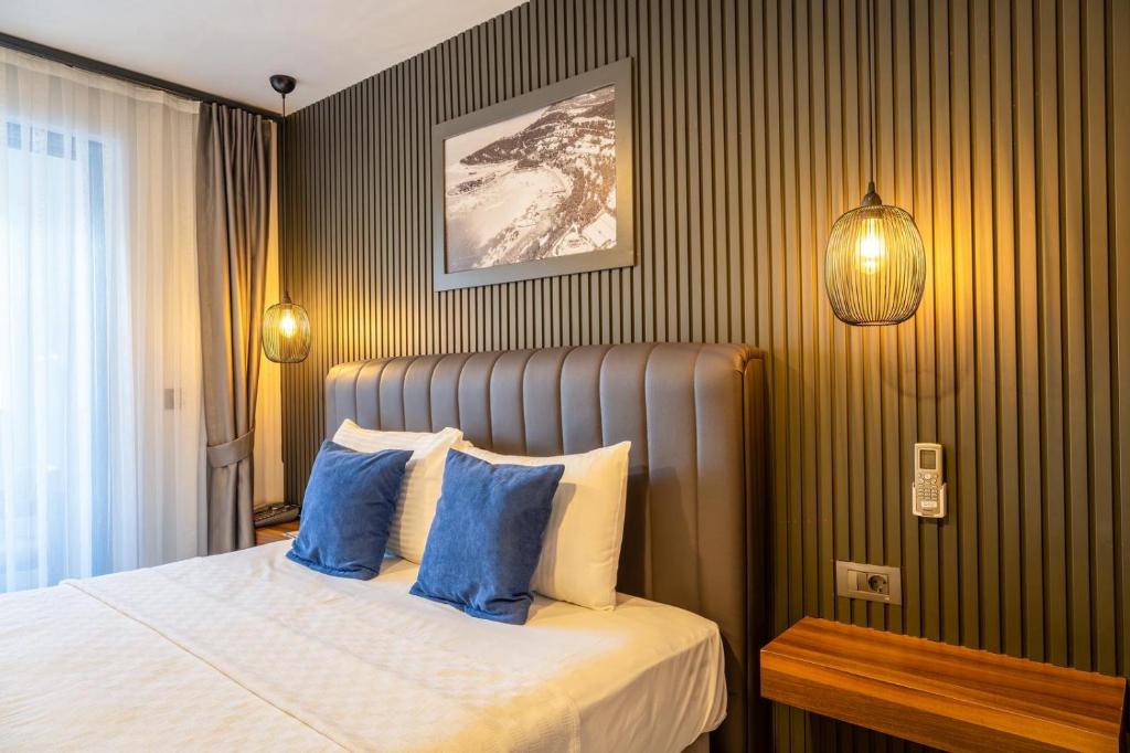 a bedroom with a bed with blue pillows at La Bonita Marina Hotel Bodrum in Bodrum City