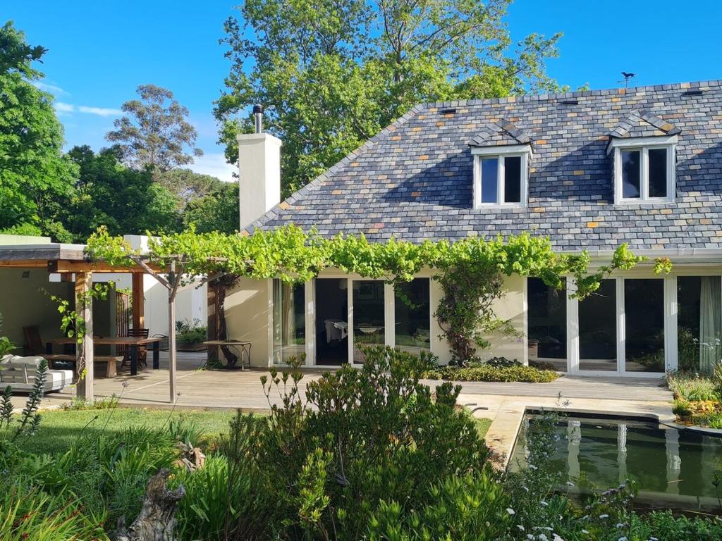 a house with a garden and a swimming pool at Tranquil Stylish Home with Nature Pool near Reserve in Somerset West