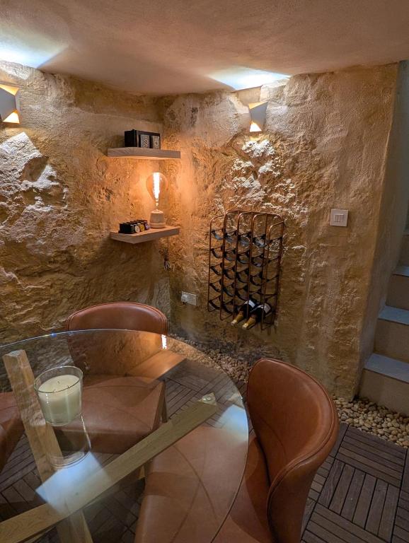 a dining room with a glass table and chairs at Sand - Rooftop Views, Wine Cellar & Espresso in Senglea