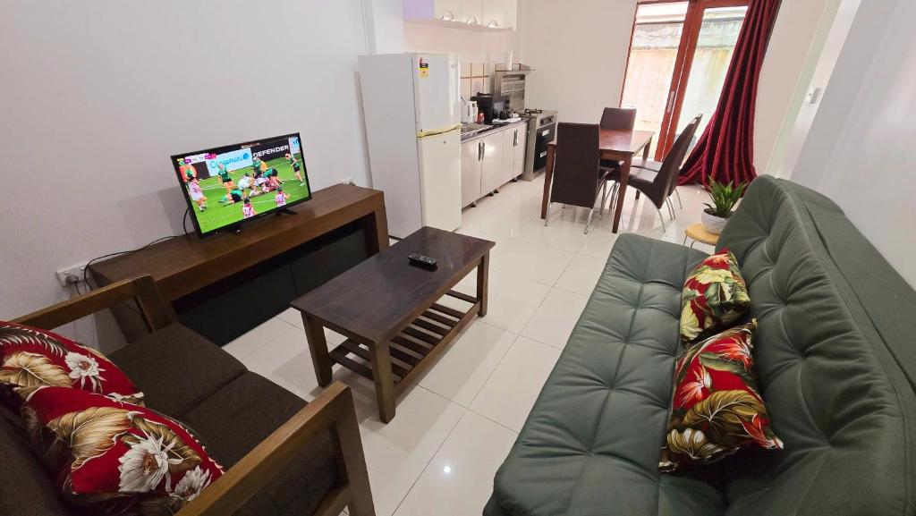 a living room with a couch and a tv at CBD Entire Apartment 102 in Suva