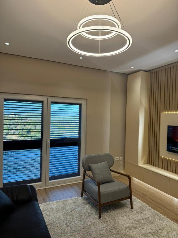 a living room with a chair and two windows at The Lake Villa in Tirana