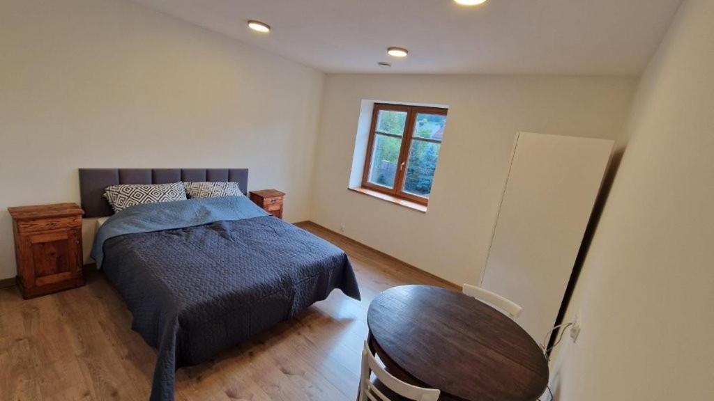 a bedroom with a bed and a table and a window at Pieniny Comfort in Krościenko