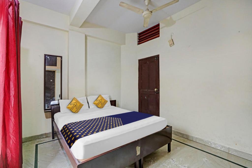 a bedroom with a bed in a room at Hotel O Vishu Moni Residency in Mysore