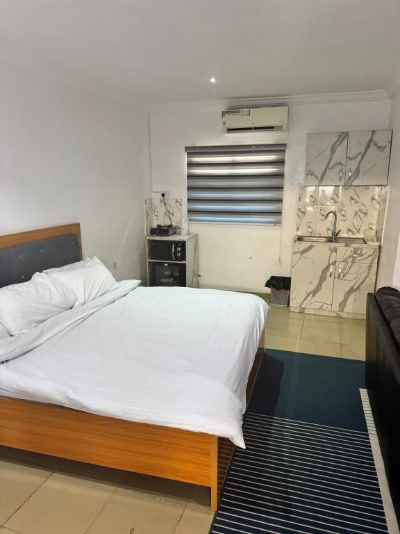 Un dormitorio con una gran cama blanca. en Ogunade Stores Apartment, en Iponri