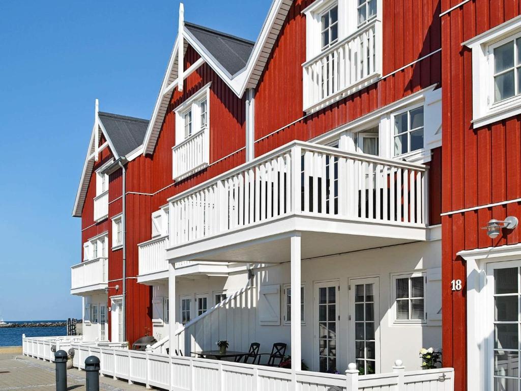 a row of red and white buildings next to the water at Seaside Escape in Bagenkop - By Traum Ferienwohnungen in Bagenkop