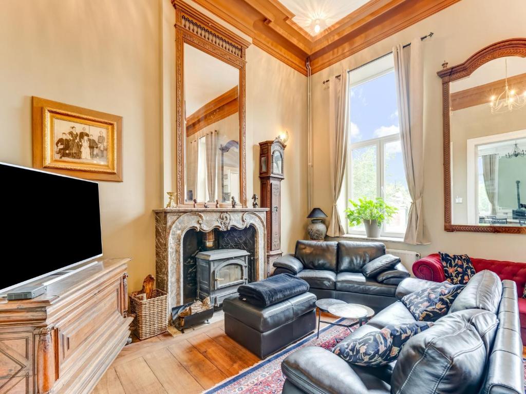 a living room with leather furniture and a fireplace at Castle with wellness and zipline in Gesves