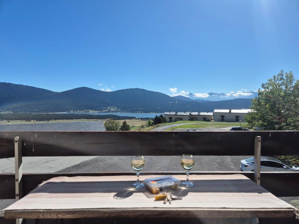 un tavolo con due bicchieri di vino sul balcone di Studio cabine Les Angles - Soleil et Montagne a Les Angles