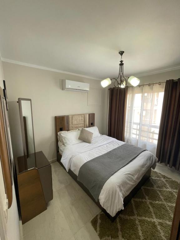 a bedroom with a large bed and a window at Modern Comforts Await! Spacious 2BR 2Bath w Free WiFi Stylish Furniture in Madinaty