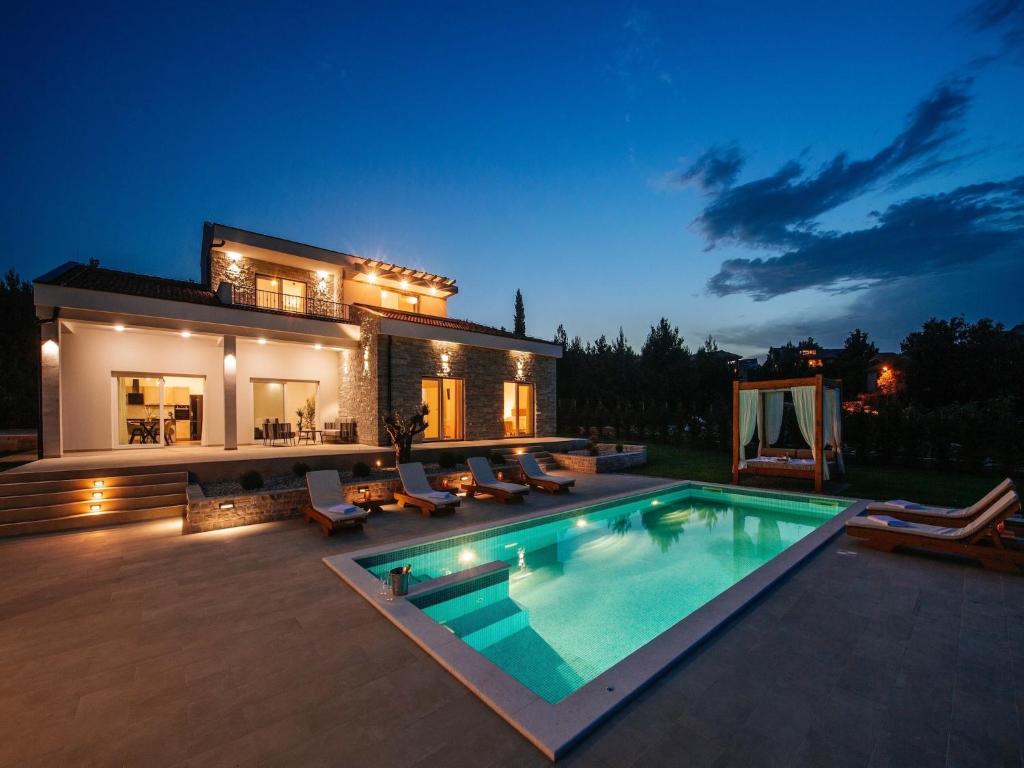 a villa with a swimming pool at night at Villa in Pridraga with Pool near the Sea in Pridraga