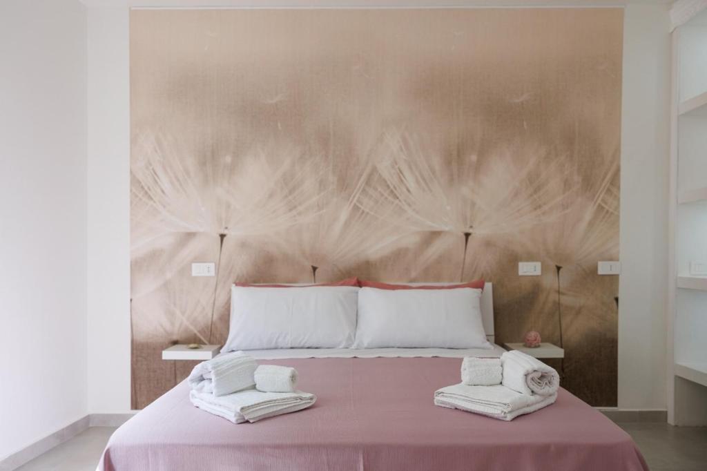 a bedroom with a large bed with two towels on it at B Luxury Home in Castellammare di Stabia