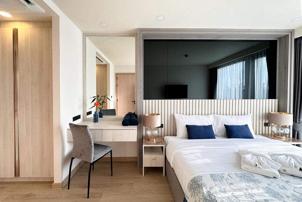 a hotel room with a large bed and a desk at Ozone Sky View Residence in Laguna Phuket
