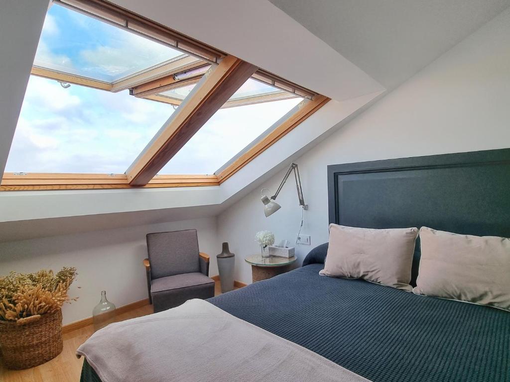 a bedroom with a large bed and a window at Marusía Home, playa Langosteira in Fisterra