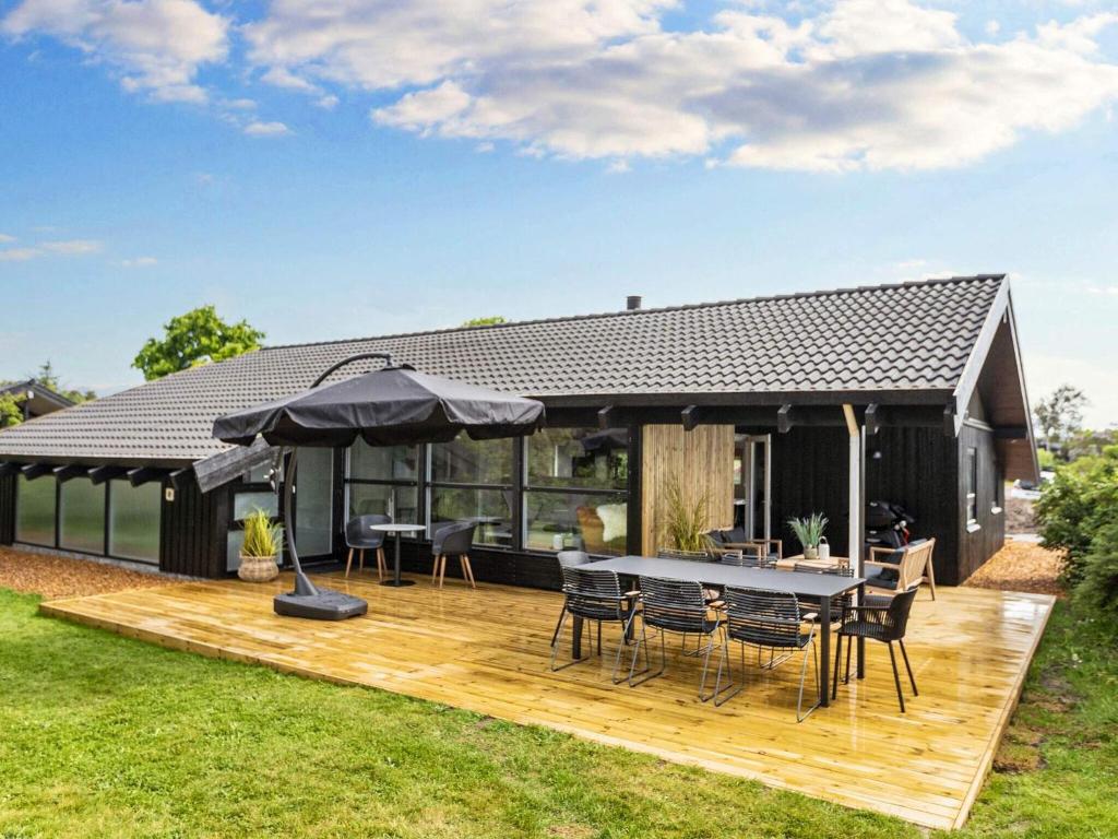 una terraza con mesa, sillas y sombrilla en 8 person holiday home in Bindslev-By Traum, en Bindslev