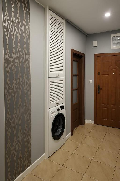 a laundry room with a washing machine in a wall at Stara słodownia in Grodków