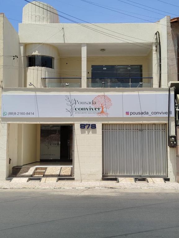 a building with a sign on the side of it at Pousada Conviver - Unidade 2 in Juazeiro do Norte