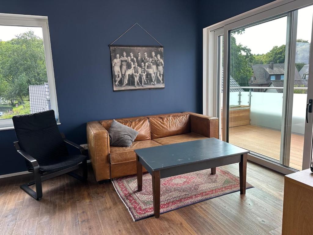 a living room with a couch and a table and a chair at Neubau FeWo in Haltern am See in Haltern
