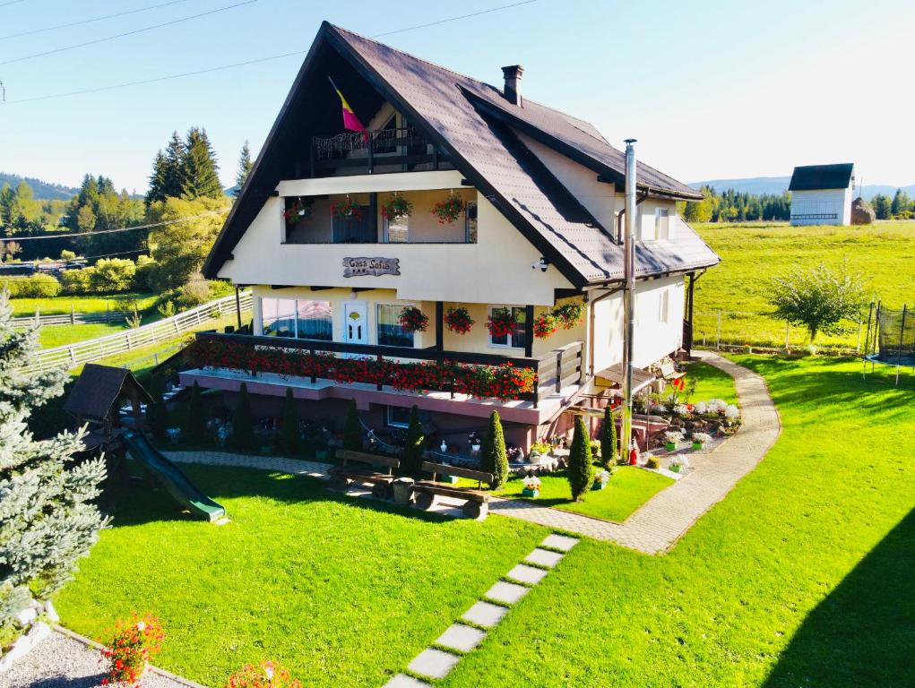 a house with a lot of people sitting outside of it at Casa Sofia Dorna Candrenilor in Dorna Cîndrenilor