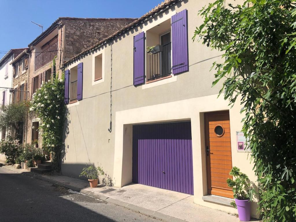 a building with purple shutters and a purple garage at La Maison de Noémie in Leucate