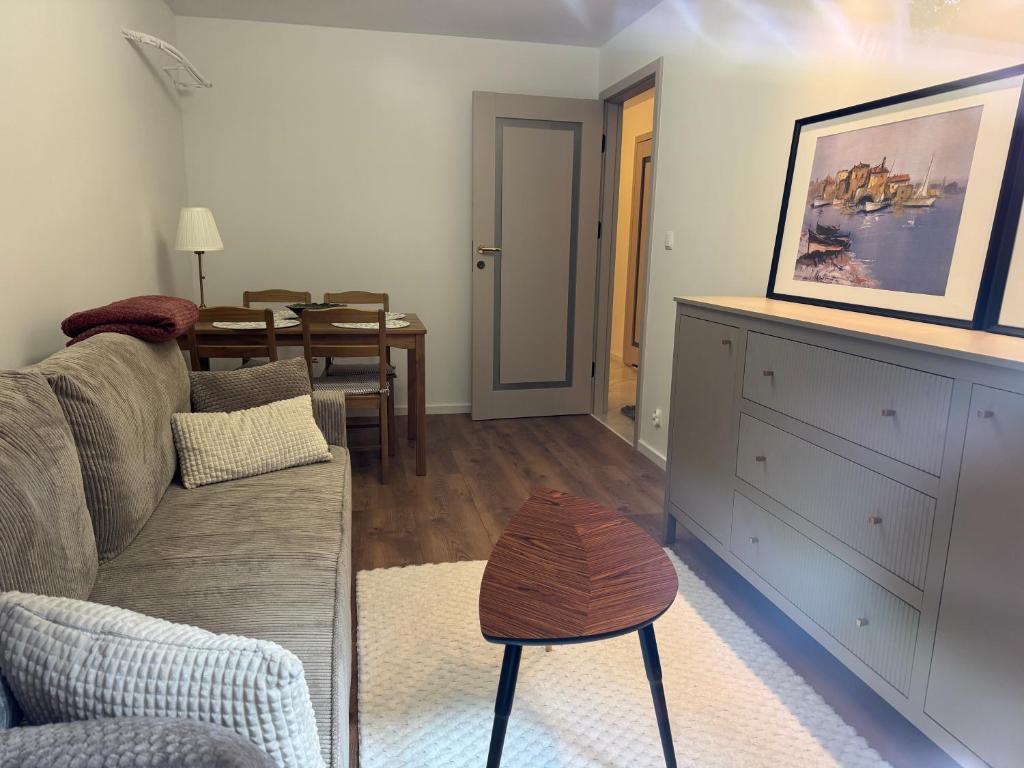 a living room with a couch and a table at Apartament - Mieszkanie, nocleg przy Centrum Zdrowia Dziecka - Warszawa Międzylesie Wawer - Dzięcieliny 15 in Warsaw