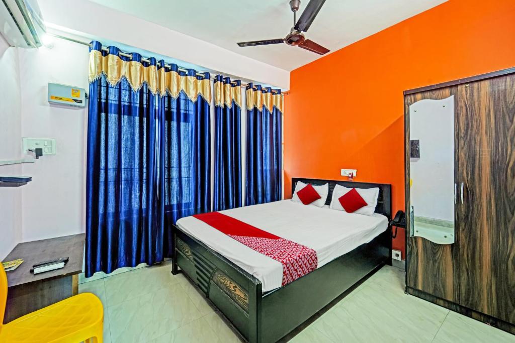 a bedroom with a bed with orange and blue curtains at Hotel O Flagship Hotel Maa Shitla in Patna