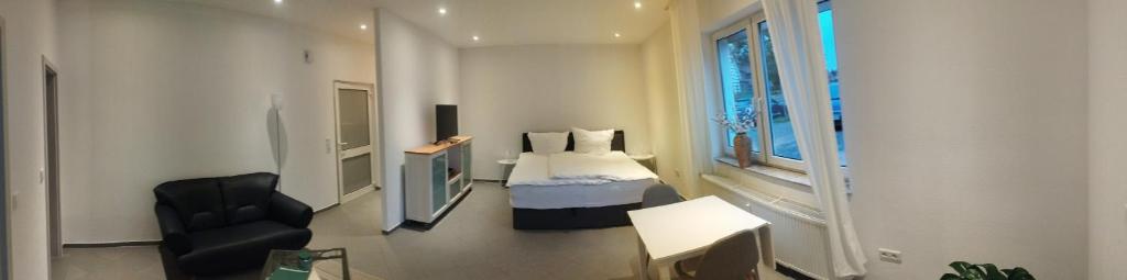 a bedroom with a bed and a chair in a room at Ecke's Apartment in Hüllhorst