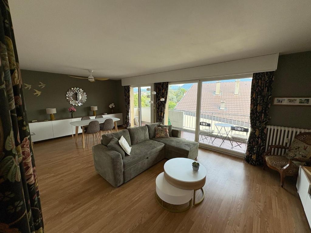 a living room with a couch and a table at Entre Lac, Fleurs et Montagnes in Thonon-les-Bains