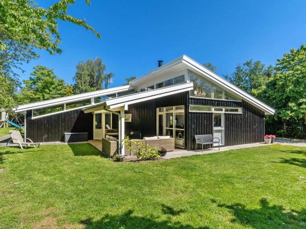 a house with a conservatory and a lawn at 8 person holiday home in Græsted-By Traum in Udsholt Sand
