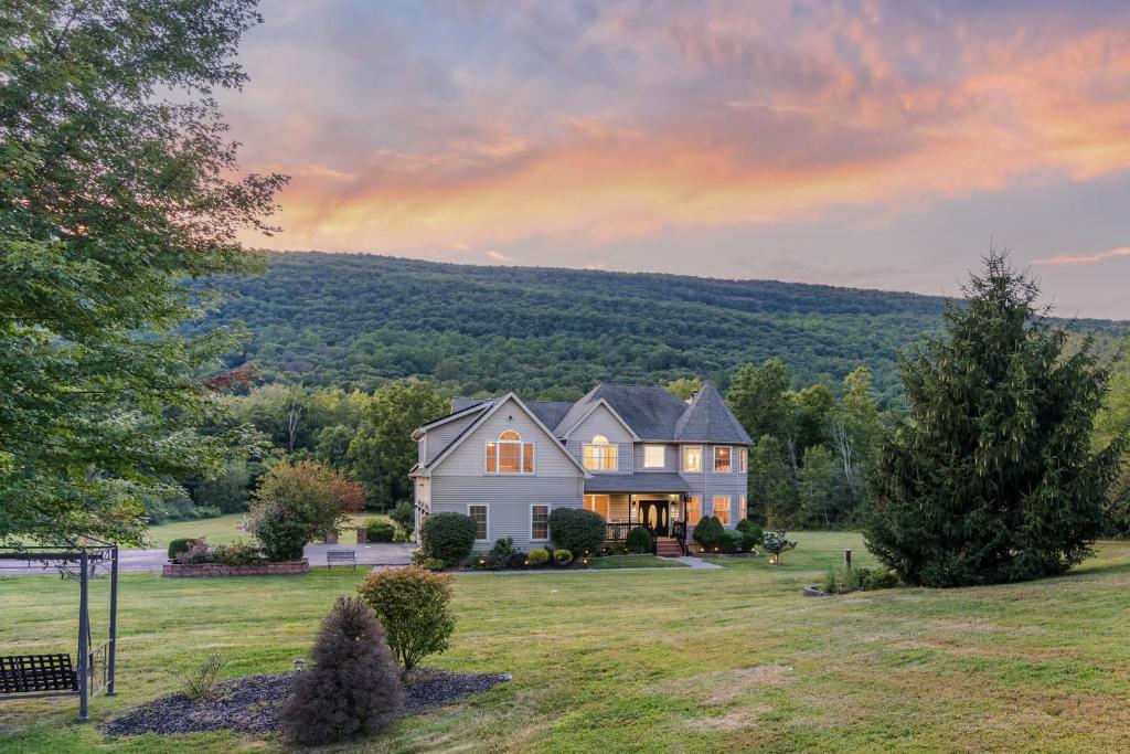 a large house on a field with a sunset at Malkita Terra -Earthly Elegance in Woodbury