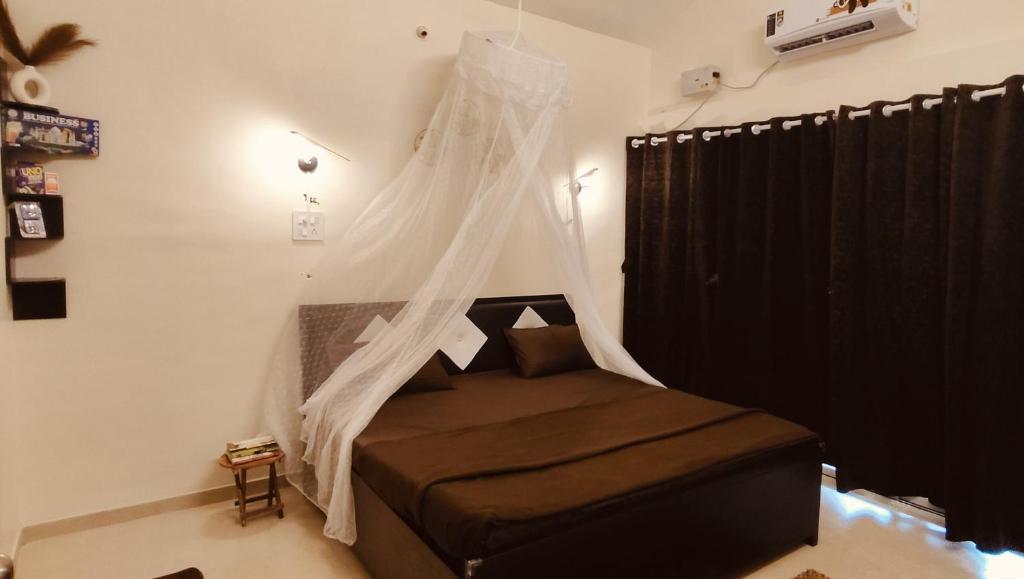 a bedroom with a bed with a mosquito net at Hillview Escape - Cozy 1bhk apartment in Karjat