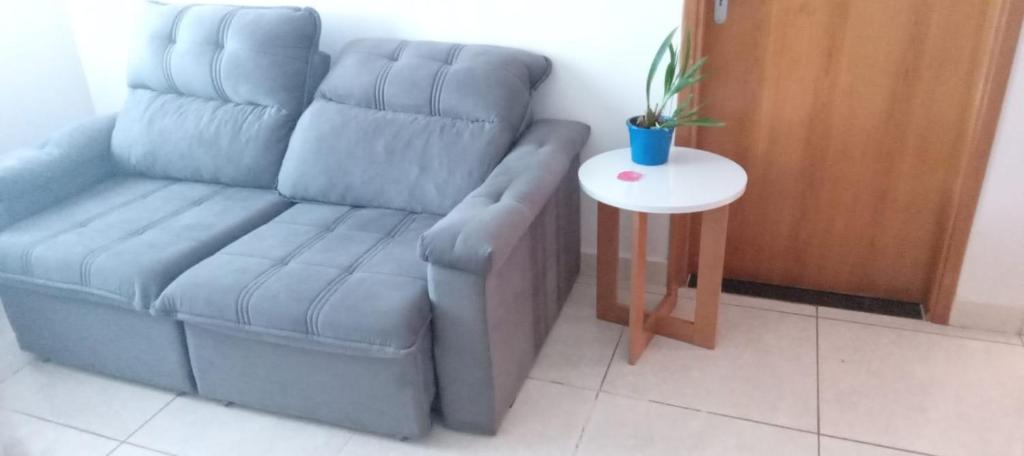 una sala de estar con un sofá y una mesa en Quarto Rustico em Alfenas, en Alfenas