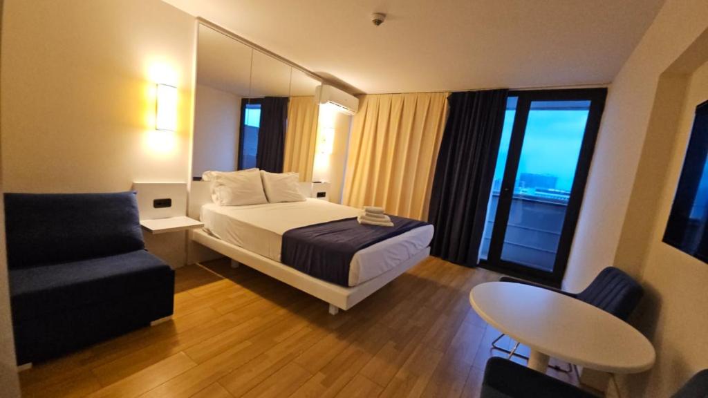 a hotel room with a bed and a chair at Premium Class Aparthotel with Sea View high floor in Batumi