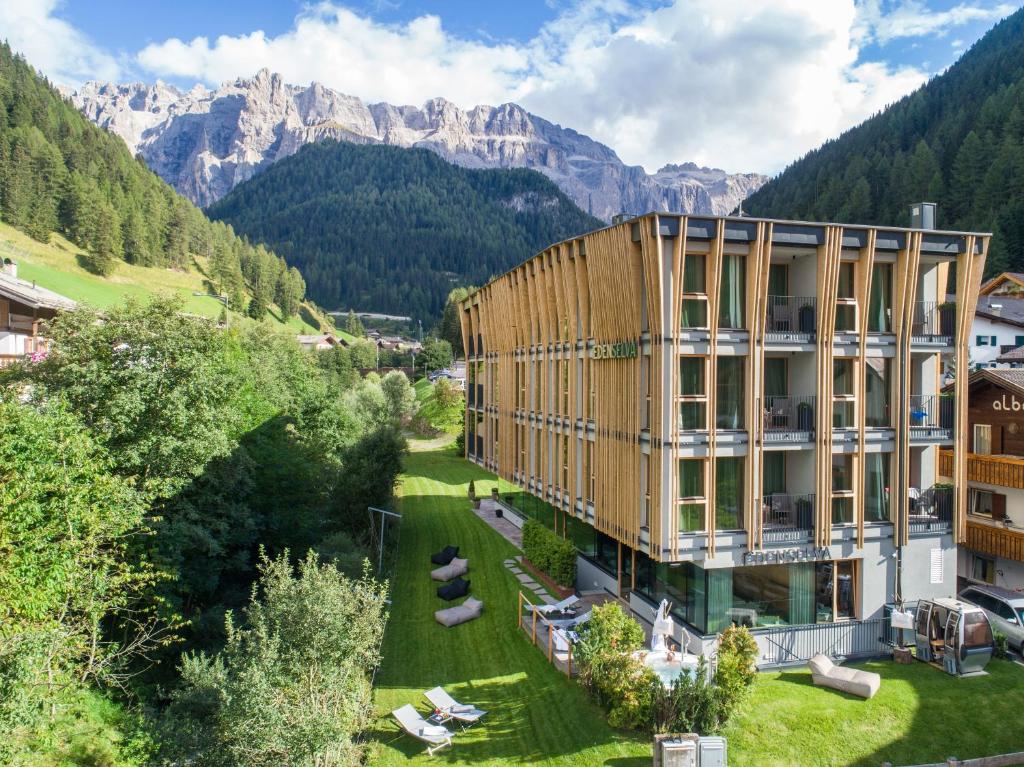 an image of a building with mountains in the background at Mountain Design Hotel Eden Selva in Selva di Val Gardena
