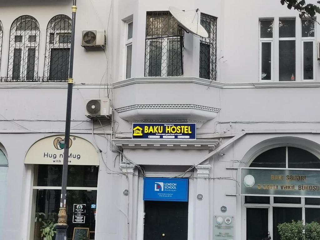 a white building with a sign on the front of it at Baku Hostel in Baku
