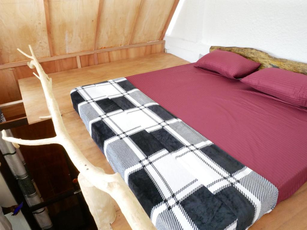 a bed with a black and white blanket on it at Ella Rustic Art Home in Badulla