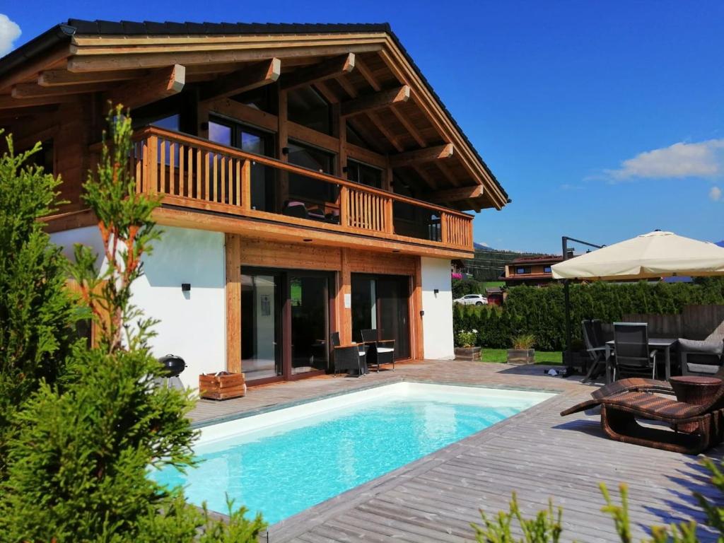 a villa with a swimming pool and a house at Chalet in Neukirchen by Wildkogel Ski Slopes in Neukirchen am Großvenediger