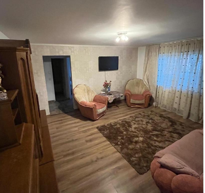 a living room with two chairs and a television at Exquisit Apartament in Buzau
