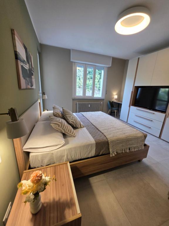 a bedroom with a bed and a table and a television at Canelli Wine Suites - Moscato & Barbera in Canelli