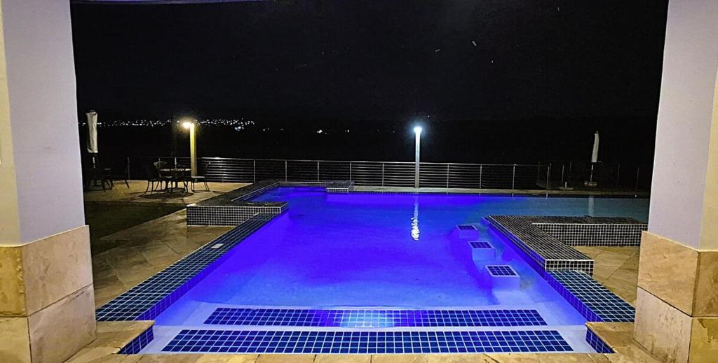 Una piscina de noche con luces violetas en Luxury Villa at Riviera Hotel Hartenbos, en Mossel Bay