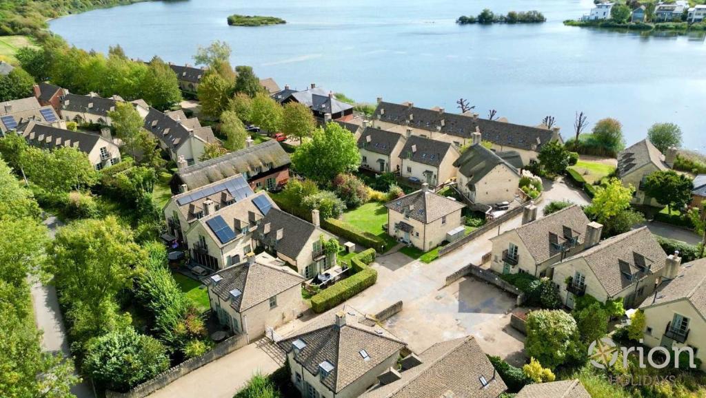 an aerial view of a town with houses and the water at Mill Village 59, Millstream Cottage - P in Somerford Keynes
